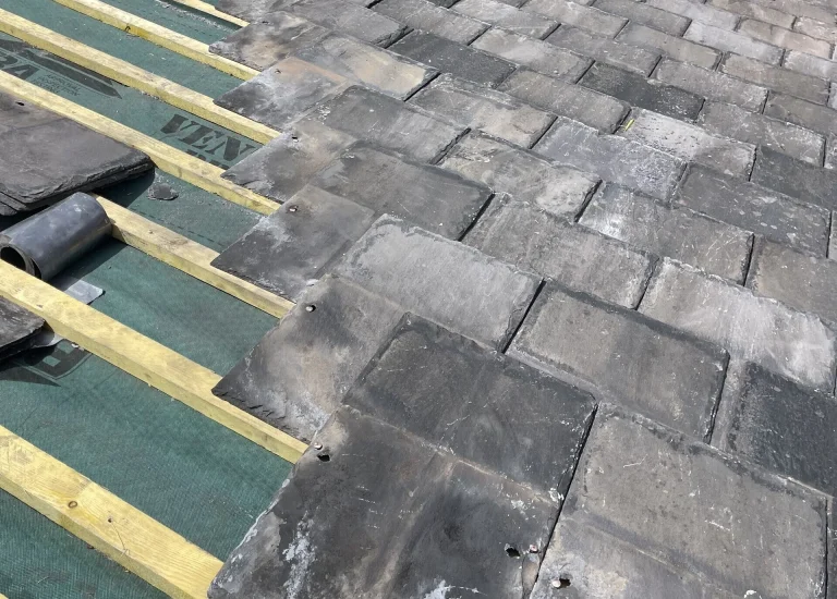 Slate roof stripped back to battens and membrane during an urgent repair
